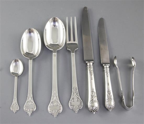 A George V silver canteen of 17th century style lace back trefid pattern cutlery, 110oz/ 3430 grams.